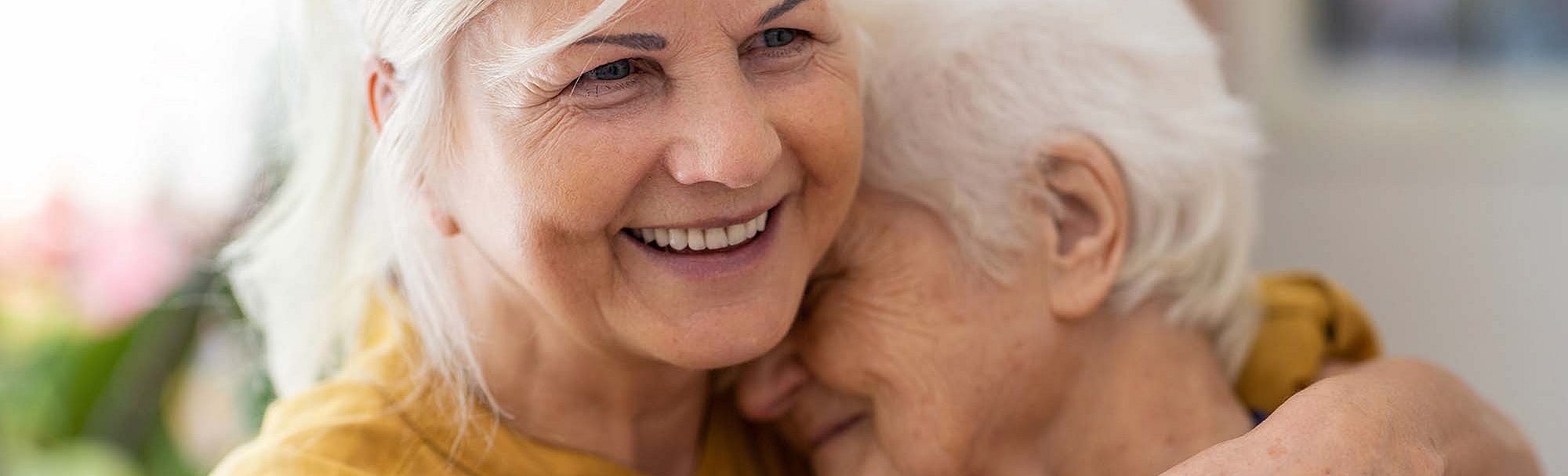 Eine Frau hält eine ältere Frau im Arm