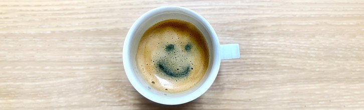 Tasse mit Kaffee, in der Crema ist ein Smiley zu sehen